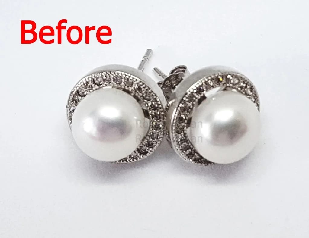 Earrings on busy surface before AI retouching